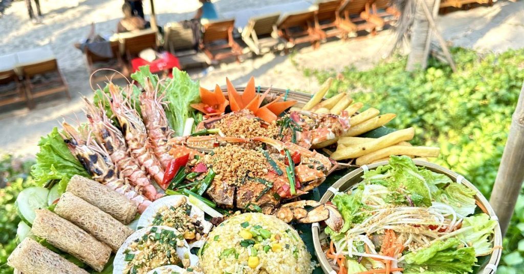 Seafood platter with prawns, crab, spring rolls and fried rice on a table at An Bang Beach